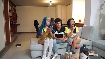 play 男は彼の隣に猫を舐めている2人の女の子とサッカーの試合を見ています
